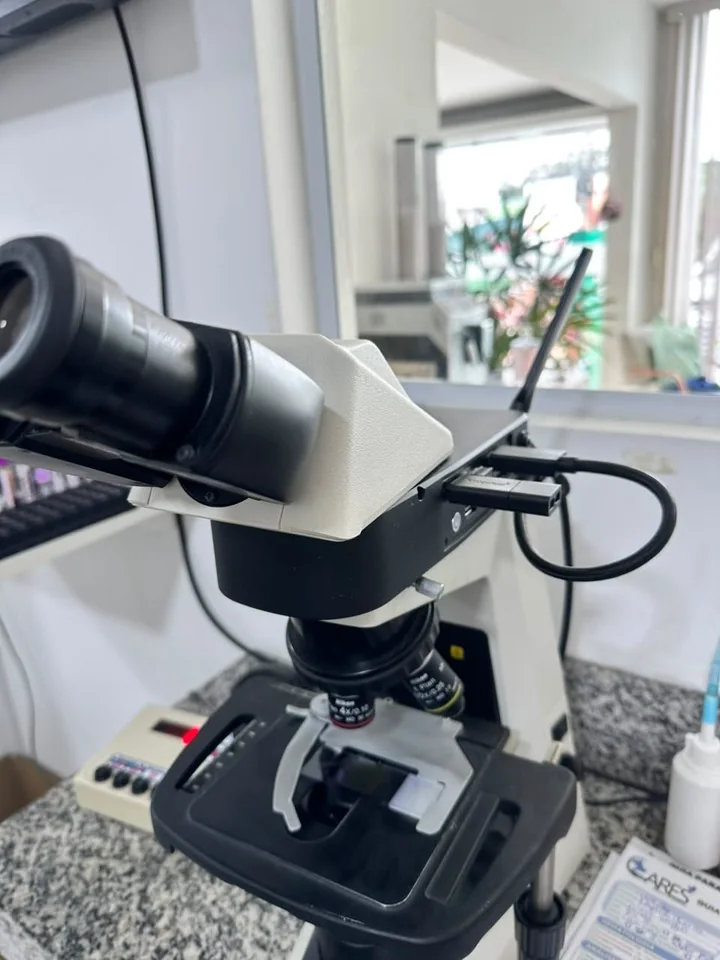 Microscópio binocular sobre a bancada do laboratório